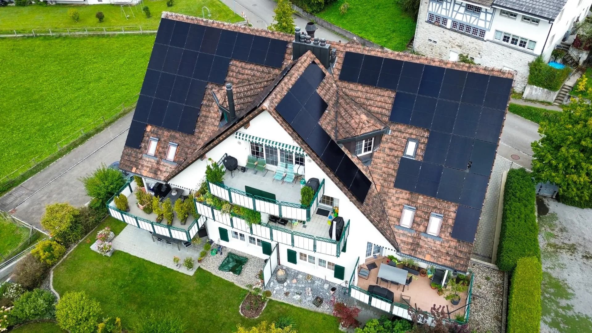 Drohnenaufnahme eines Mehrfamilienhauses in Zürich mit 58 Solarmodulen auf dem Dach, installiert im September 2025. Die Anlage ermöglicht sieben Familien, gemeinsam rund 27'000 kWh Solarstrom pro Jahr zu nutzen.